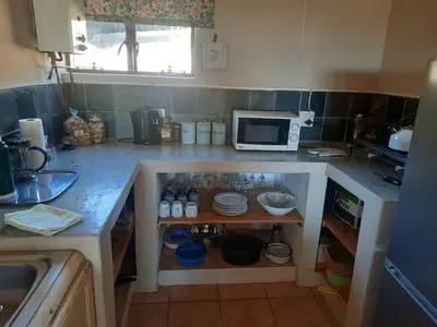 a small kitchen with a counter with a microwave at Kwaggaskop Farm Stoephuis in Dullstroom