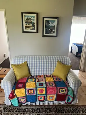 a couch with a colorful blanket on it in a living room at Kwaggaskop Farm Stoephuis in Dullstroom
