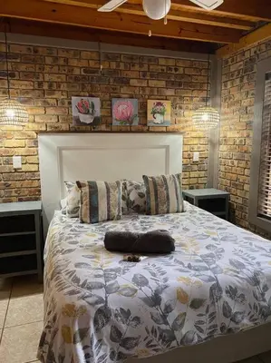 a bedroom with a large bed in a brick wall at Kudu's Rus in Marloth Park in Marloth Park