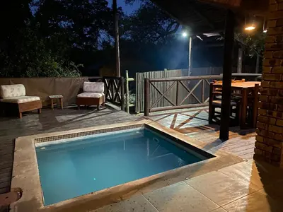 a swimming pool on a deck with a table and chairs at Kudu's Rus in Marloth Park in Marloth Park