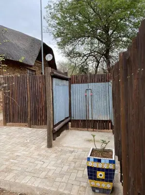 a wooden fence with a potted plant in front of a gate at Kudu's Rus in Marloth Park in Marloth Park