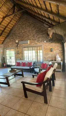 a living room with tables and couches in a building at Kudu's Rus in Marloth Park in Marloth Park