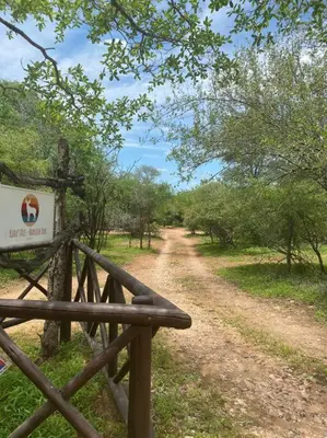 a dirt road with a sign next to a fence at Kudu's Rus in Marloth Park in Marloth Park