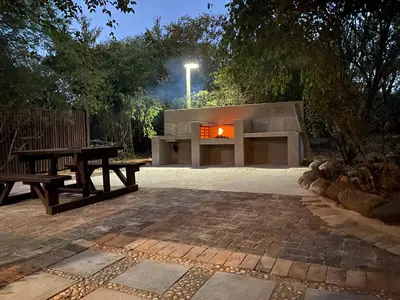 a fire pit and a picnic table in a backyard at Kudu's Rus in Marloth Park in Marloth Park