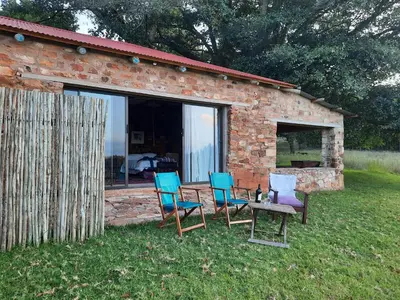 a group of chairs and a table in front of a building at Kwaggaskop Farm Kliphuis in Dullstroom