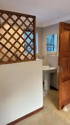 a bathroom with a sink and a toilet and a door at Dullstroom Self Catering Blue Crane Estate 66 in Dullstroom