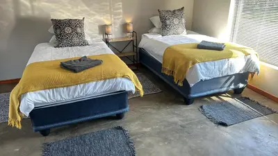 two beds sitting next to each other in a bedroom at Dullstroom Self Catering Blue Crane Estate 66 in Dullstroom