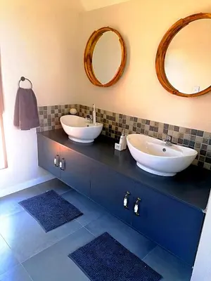 a bathroom with two sinks and mirrors on a counter at Ndlovu Bushvilla at Elephant Rock Eco Estate in Mica