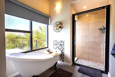 a bathroom with a large tub and a shower at Ndlovu Bushvilla at Elephant Rock Eco Estate in Mica