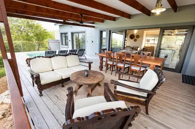 a screened porch with furniture and a table and chairs at Ndlovu Bushvilla at Elephant Rock Eco Estate in Mica