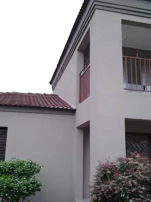 a white building with a balcony and a tree at Bushbuckridge Micanolia Guest House in Dwarsloop