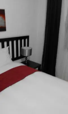a bedroom with a white bed with a red blanket at Bushbuckridge Micanolia Guest House in Dwarsloop