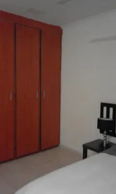 a bedroom with wooden cabinets and a bed and a chair at Bushbuckridge Micanolia Guest House in Dwarsloop