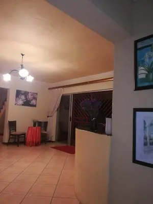 a living room with a table and chairs and a room at Bushbuckridge Micanolia Guest House in Dwarsloop