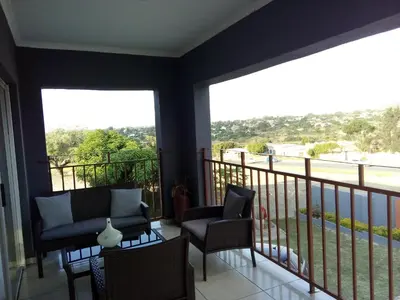 a balcony with chairs and windows with a view at Bushbuckridge Micanolia Guest House in Dwarsloop
