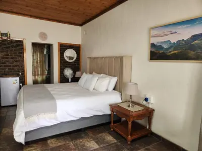 a bedroom with a large bed and a table at Tree Orchid in Polokwane