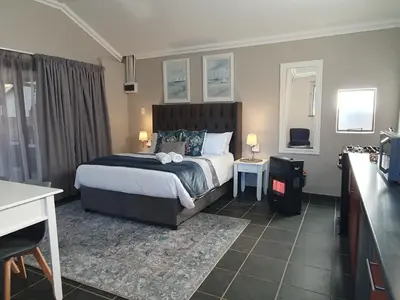 a hotel room with a bed and a desk at Tree Orchid in Polokwane