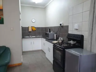 a small kitchen with a stove and a sink at Tree Orchid in Polokwane