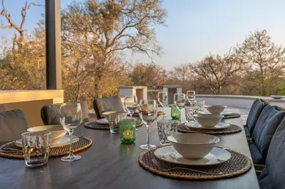 a table with wine glasses and plates on it at Villa Lanterfant - luxury stay in nature - solar powered in Hoedspruit