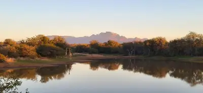 a river with trees and mountains in the background at Villa Lanterfant - luxury stay in nature - solar powered in Hoedspruit
