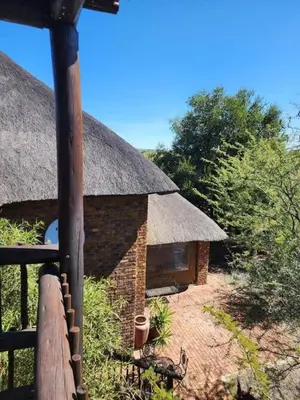 a small brick building with a thatched roof at Bateleur Lodge, Mabalingwe in Bela-Bela