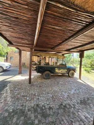 an old car parked under a wooden roof at Bateleur Lodge, Mabalingwe in Bela-Bela