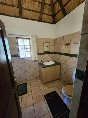 a bathroom with a sink and a toilet at Bateleur Lodge, Mabalingwe in Bela-Bela