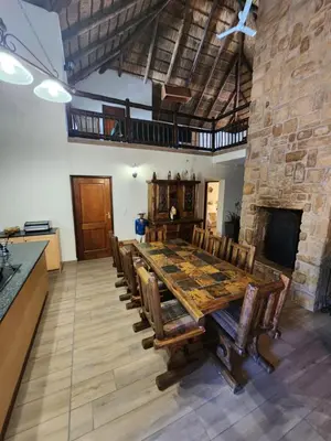 a large dining room with a wooden table and chairs at Bateleur Lodge, Mabalingwe in Bela-Bela