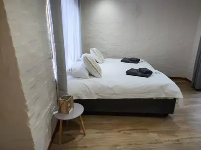 a small bed in a room with a small table at Boomhuis, Mabalingwe Nature Reserve in Bela-Bela