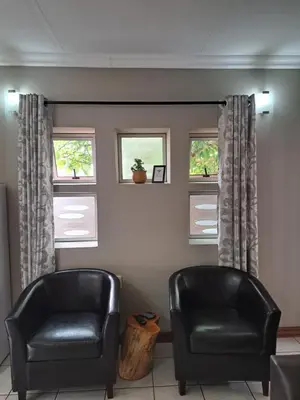 two black leather chairs in a room with windows at Partridge Place in Kempton Park