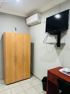 a room with a cabinet and a television on a wall at Lugogo Guesthouse in Thohoyandou