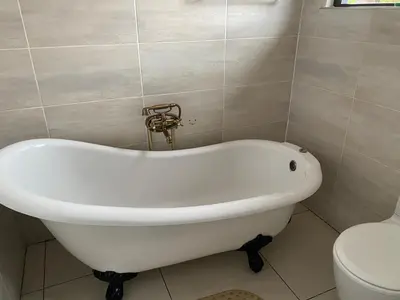 a white bath tub in a bathroom with a toilet at Bridgelamour Accommodation in Hartbeespoort