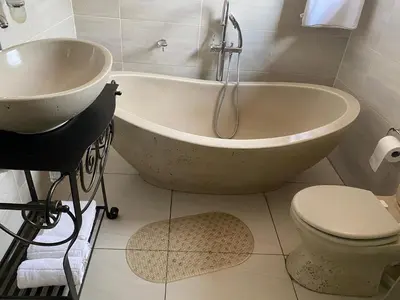 a bathroom with a tub and a toilet and a sink at Bridgelamour Guest House in Hartbeespoort