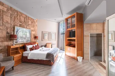 a bedroom with a king sized bed and a bathroom at Villa Africa Boutique Hotel & Spa in Pretoria
