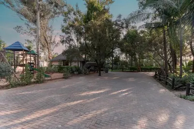 a brick road with trees in a park at Villa Africa Boutique Hotel & Spa in Pretoria
