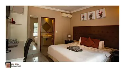 a bedroom with a bed with a hat on it at Villa Africa Boutique Hotel & Spa in Pretoria