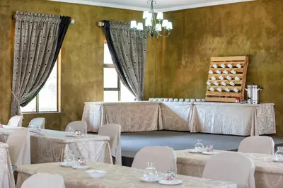 a banquet room with tables and chairs and a chandelier at Bluegum Country Lodge in Bethal
