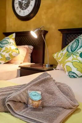 a bed with a blanket and a clock on the wall at Bluegum Country Lodge in Bethal