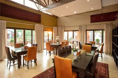 a dining room with tables and chairs and windows at Bluegum Country Lodge in Bethal