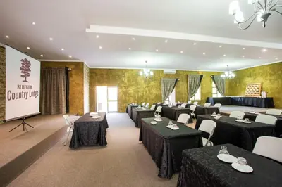 a conference room with tables and chairs and a screen at Bluegum Country Lodge in Bethal