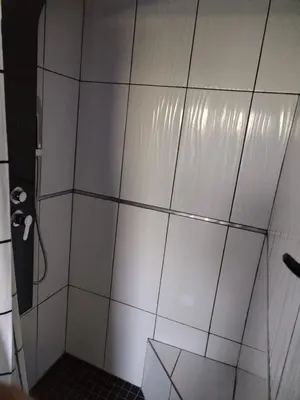 a bathroom with a shower with white tiles at Waterfront Guest House in Hartbeespoort