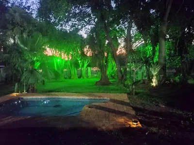 a pool in a yard with green lights at Waterfront Guest House in Hartbeespoort