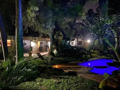 a night view of a house with a swimming pool at Waterfront Guest House in Hartbeespoort