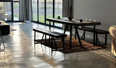 a living room with a table and benches in a room at Sango on 9 in Naboomspruit
