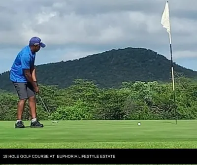 a man playing golf on a golf course with a flag at Sango on 9 in Naboomspruit