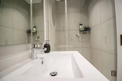a white sink in a bathroom with a shower at Beautiful Gem at Ellipse in Midrand