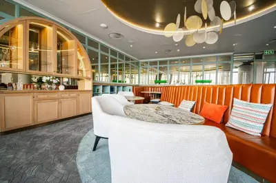 a kitchen with a table and white chairs and cabinets at Beautiful Gem at Ellipse in Midrand