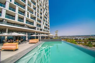 a hotel swimming pool with chairs and a building at Beautiful Gem at Ellipse in Midrand