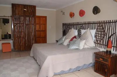 a bedroom with a bed with white sheets and pillows at Mon Repos Guest Farm in Bela-Bela