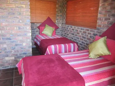 two beds in a room with pink and purple sheets at Mon Repos Guest Farm in Bela-Bela